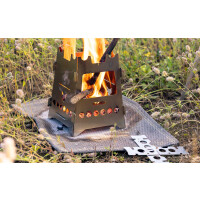 FENNEK Hobo Steckvariante Basic aus Edelstahl steht brennend auf einer Wiese